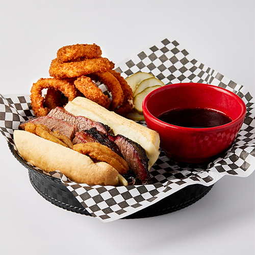 A plate of food with onion rings and hot dog.